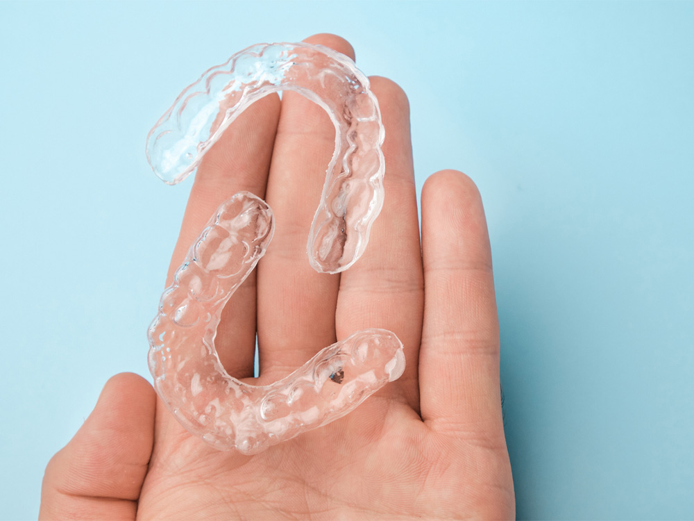 person holding a set of clear aligners