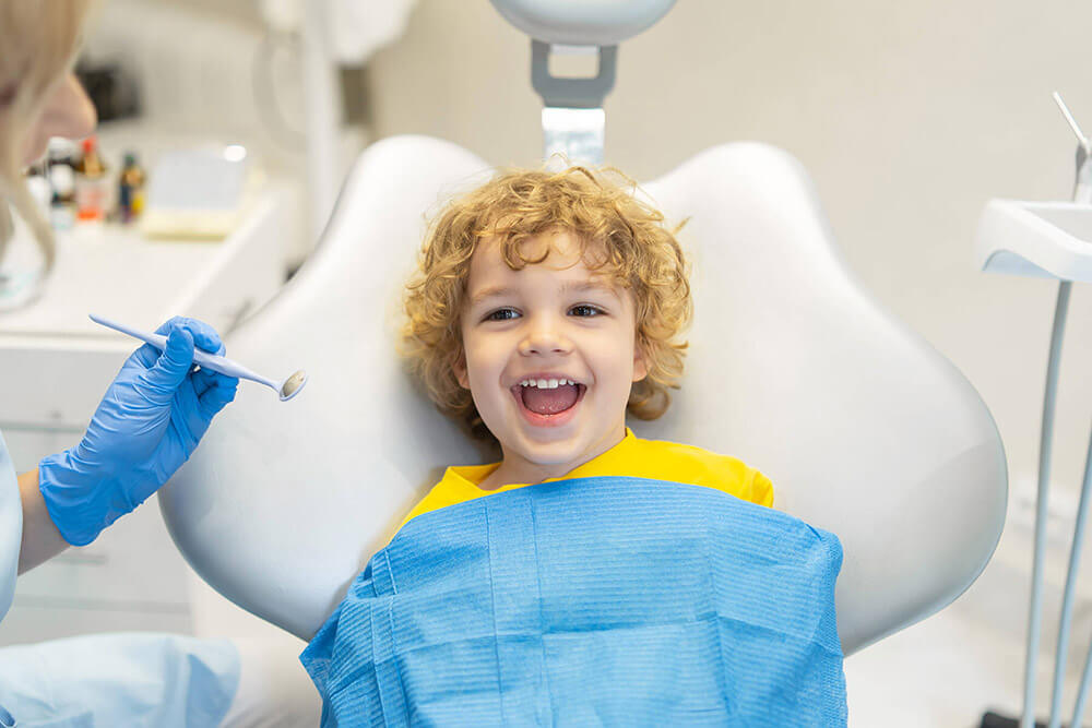 child sitting in dental chair smiling